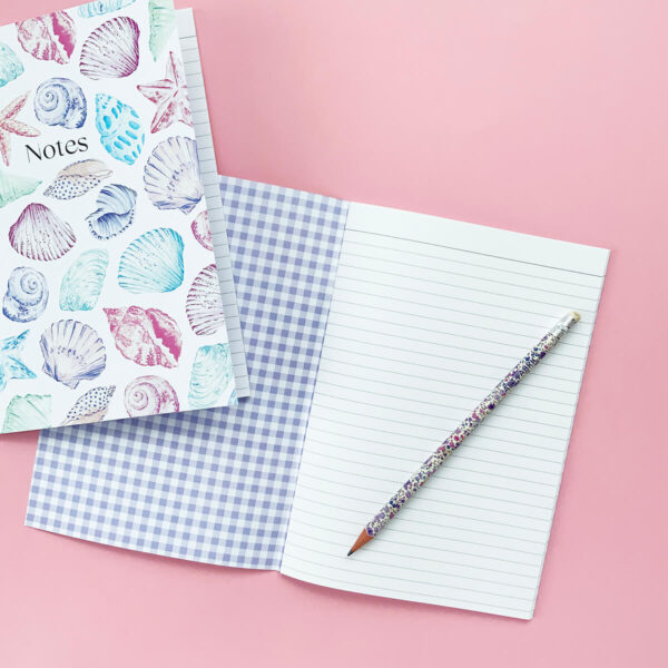 inside the shell print notebook with a pencil