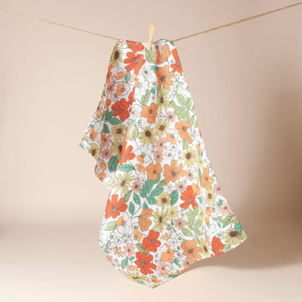 Peach floral tea towel hanging on a washing line